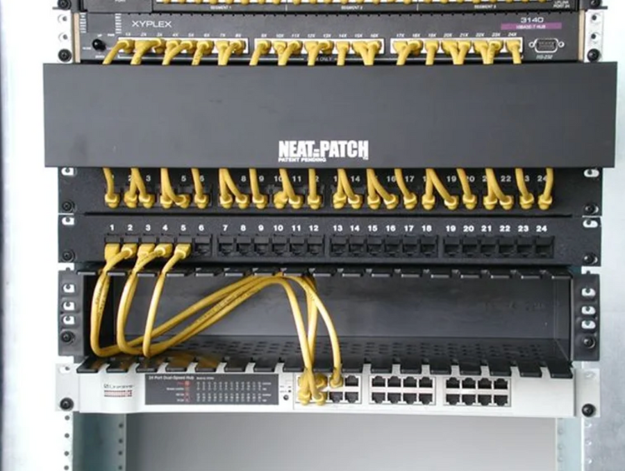 Customer photo showing NEAT-PATCH cable management maintaining clean routing despite uneven port alignment