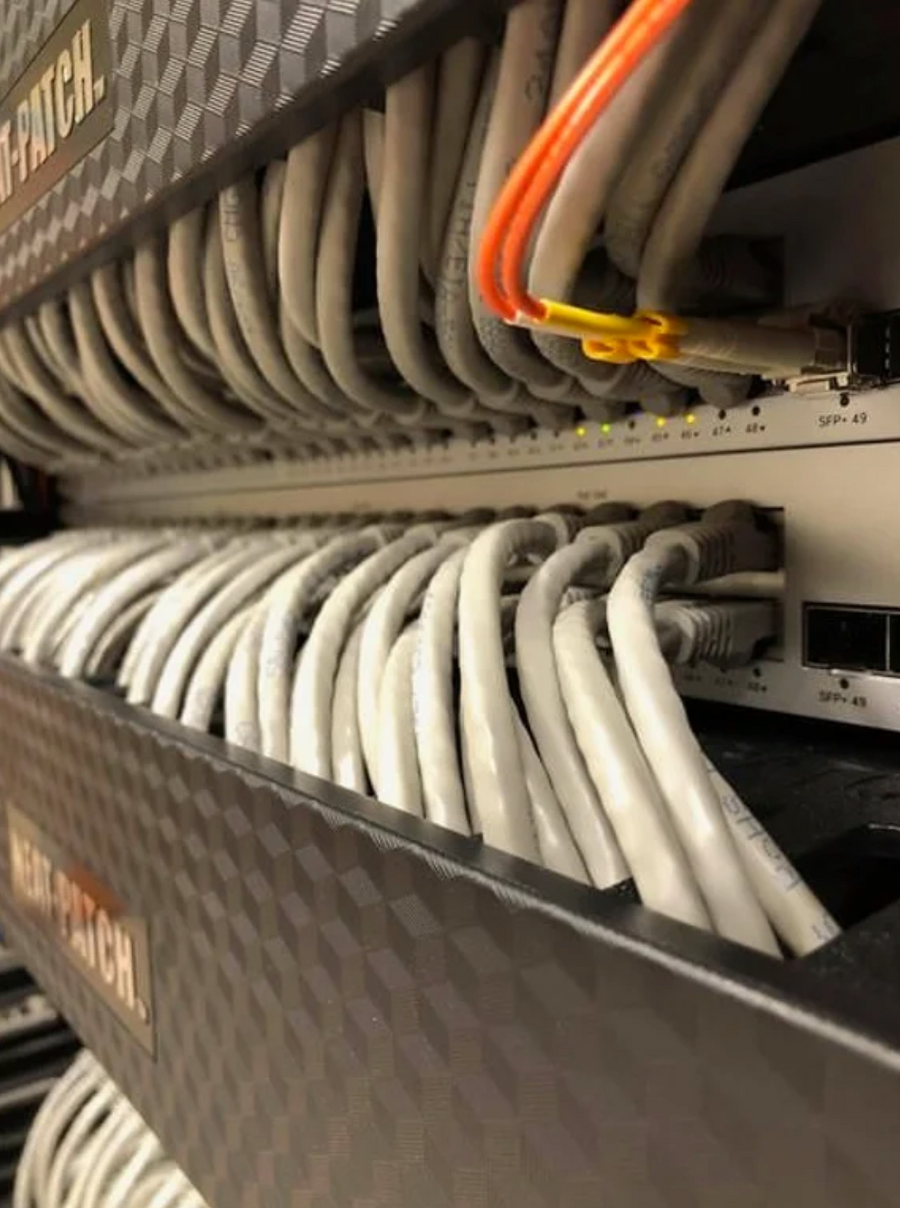 Close-up of NEAT-PATCH network cable management system maintaining uniform bend radius across patch panel ports