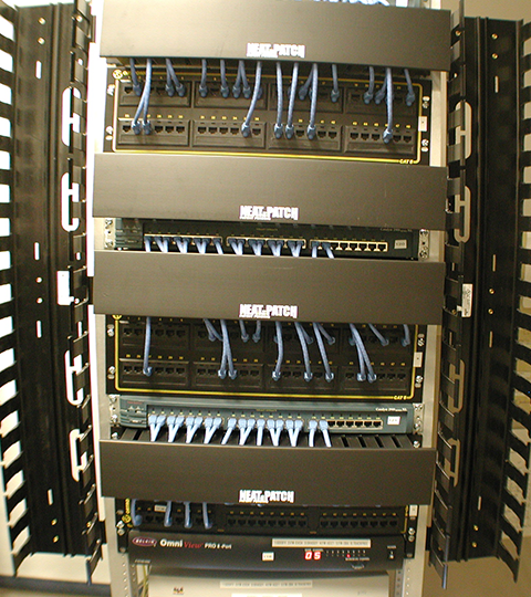NEAT-PATCH rack installation showing empty front vertical managers, proving vertical cable management is unnecessary