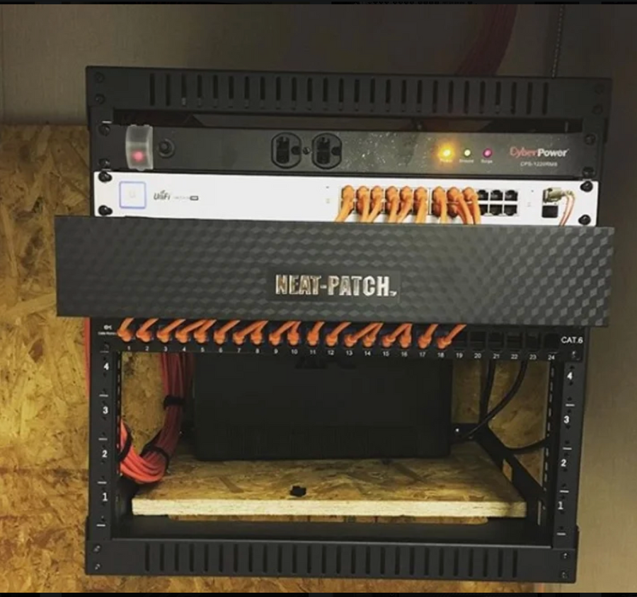 Customer photo of NEAT-PATCH cable management in wall-mounted network rack with organized CAT6 patch cables