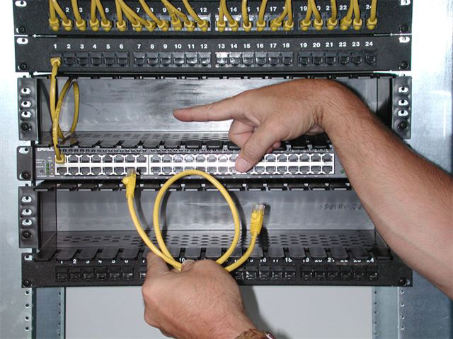 Technician servicing accessible patch connections in a Neat-Patch network rack